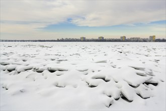 Ukraine, Dnepropetrovsk region, Dnepropetrovsk city, Frozen river with distant cityscape