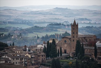 Italy, Tuscany, Siena, Evening view of Basilica of Saint Maria Dei Servi and beautiful hills behind