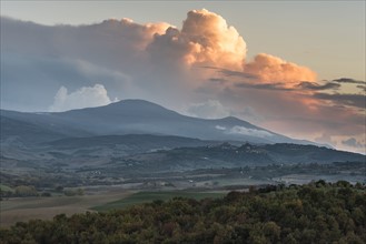 Italy, Tuscany, San Quirico D'orcia, Landscape in evening with flaming clouds in sky