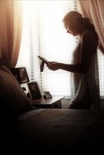 Woman in bedroom looking at photo