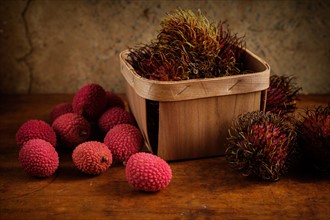 Organic lychee in basket and on wooden table