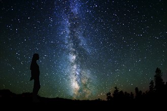 Silhouette of woman against Milky Way