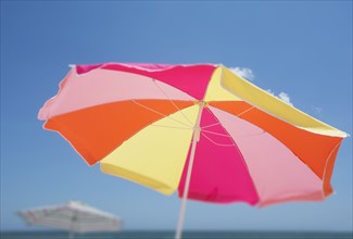 Colorful beach umbrella against blue sky