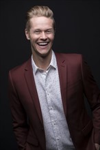 Portrait of laughing man wearing maroon suit