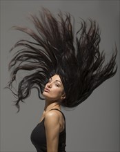 Brunette woman flipping long hair