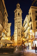 Spain, Valencian Community, Valencia, Tower of Santa Catalina, Pedestrians on narrow street in old town at night
