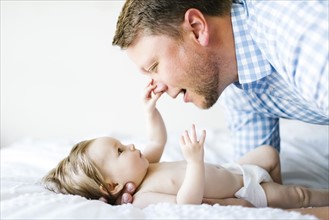 Baby girl (6-11 Months) catching father`s nose