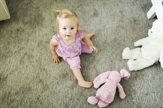 Portrait of baby girl (12-17 months) sitting on floor