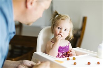 Father feeding baby girl (12-17 months)