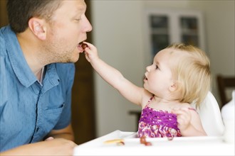 Baby girl (12-17 months) feeding her father