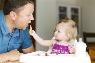 Baby girl (12-17 months) feeding her father
