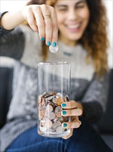 Woman putting coin into glass