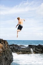 Young man jumping into sea