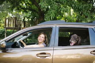 Woman and Labrador Retriever sitting in car