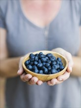 Woman holding bowl with blueberries