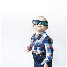 Studio shot of baby boy (12-17 months) wearing sunglasses