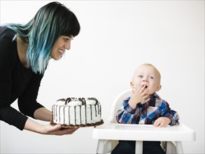 Mother holding birthday cake for son (12-17 months)