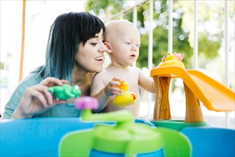 Mother with baby boy (12-17 months) playing with inflatable toys