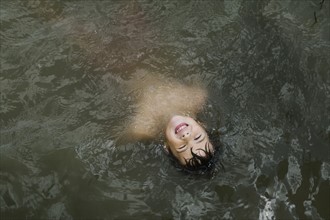 Boy (6-7) floating in lake