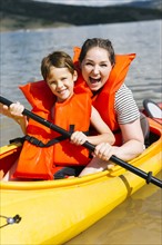 Mother with son (6-7) kayaking on lake