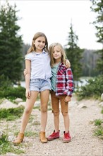Outdoor portrait of brother (6-7) and sister ( 8-9) in forest