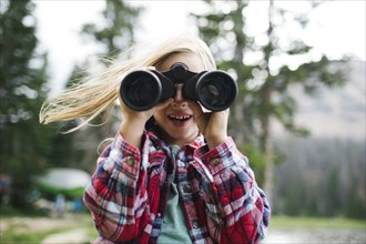 Portrait of boy (6-7) looking through binoculars
