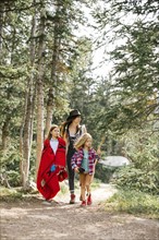 Mother with son (6-7) and daughter (8-9) hiking in forest