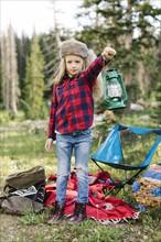 Portrait of boy (6-7) with camping gear in forest