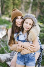 Portrait of mother with daughter (8-9) hiking in forest