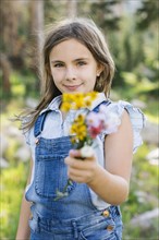 Portrait of girl (8-9) holding wildflowers