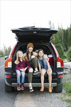 Portrait of woman with son (6-7) and daughter (8-9) in back of car
