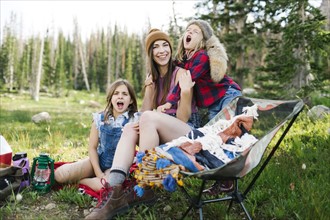 Mother with son (6-7) and daughter (8-9) camping in forest