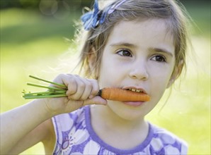 Little girl (4-5) eating carrot