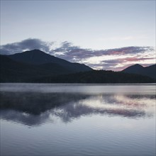 USA, New York, Lake Placid, Mountain and clouds reflecting in lake