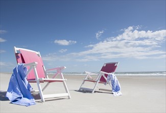Two deckchairs on empty beach