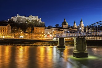 Austria, Salzburg, Riverbank with buildings at night