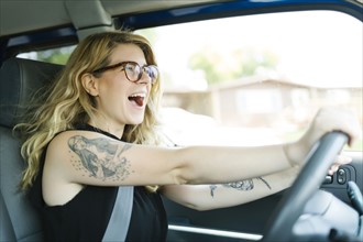 Woman driving car and laughing
