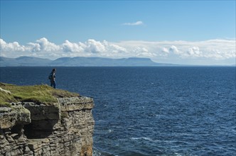 Ireland, Donegal County, Muckross Head, Woman standing on top of cliff