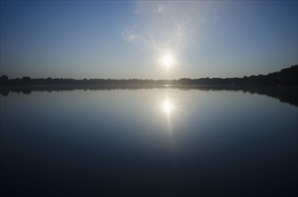 Sun rising above lake