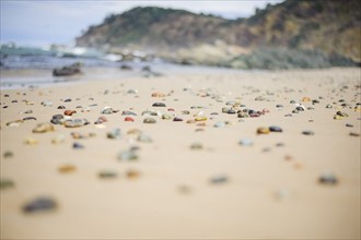 Australia, New South Wales, Colorful stones on sandy beach