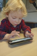 Little boy (2-3) playing game on smart phone