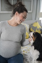 Pregnant woman looking at dog