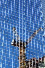 USA, New York, New York City, Crane reflecting in glass wall