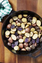 Close up of roasted potatoes in skillet on table