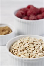 Close up of oats and raspberries in bowls