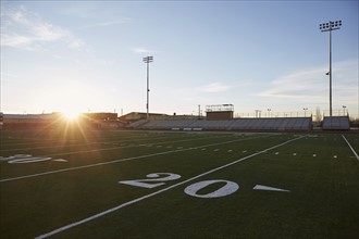 Forty yard line on green playing field at sunset