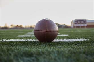 Close up of American football ball on green playing field