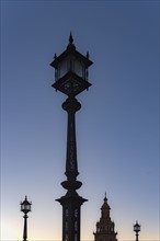 Spain, Andalusia, Seville, Plaza de Espana, Old fashioned street lights against clear sky at dawn
