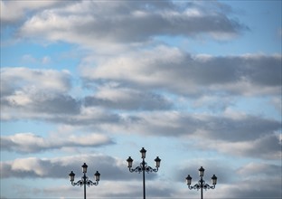 Spain, Andalusia, Seville, Neoclassical style street lights against cloudy sky