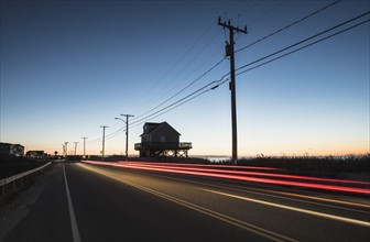 USA, Massachusetts, Cape Cod, Falmouth, Blurred taillight of car on road at dawn